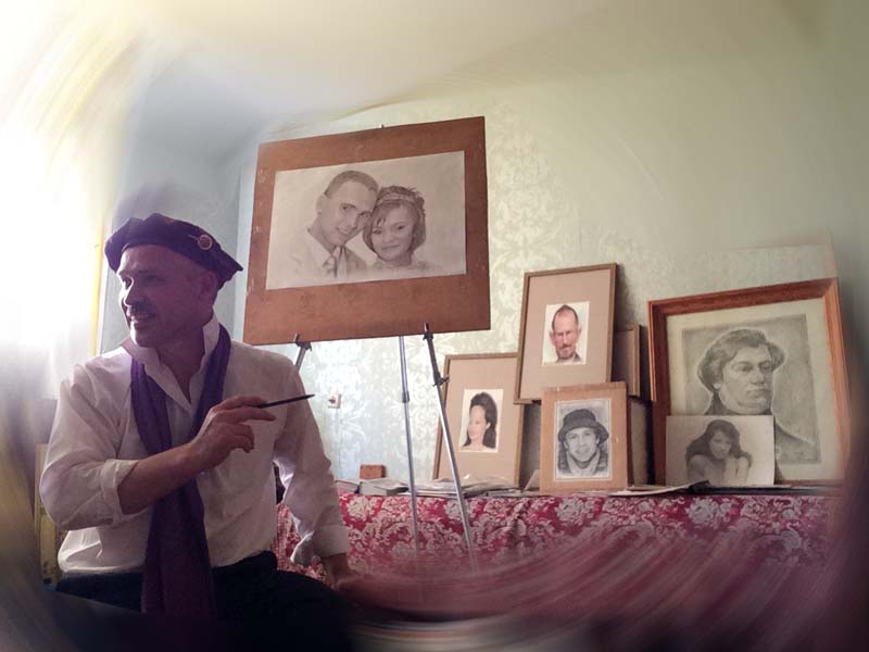 шаржист в мастерской на фоне портретов и шаржей Михаил Шабалин